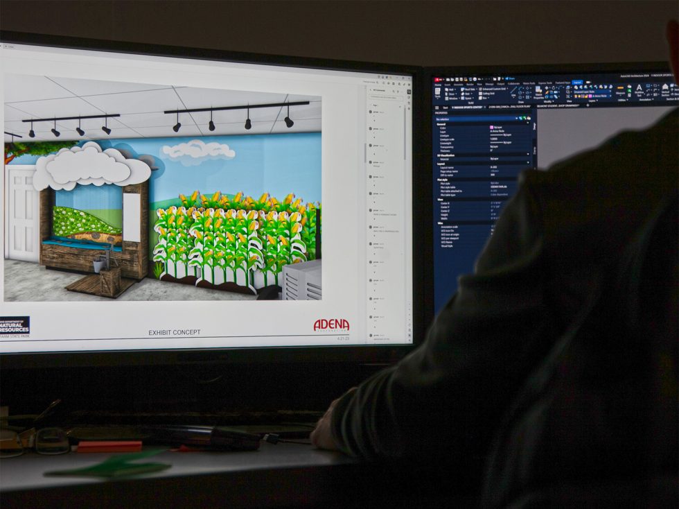 Man working on exhibit design at computer