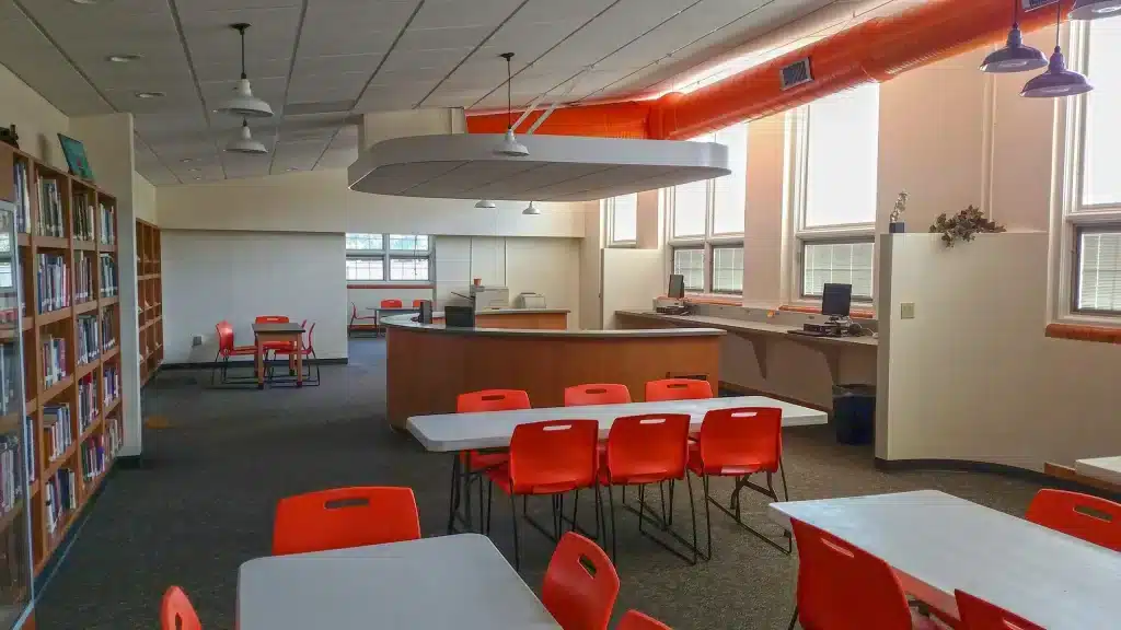 Library space with tables and bright red chairs