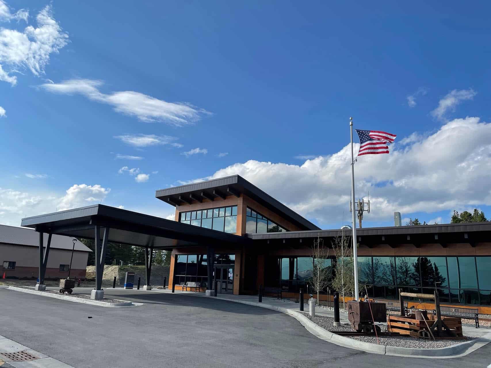 Wood paneled one story building with car drop off area