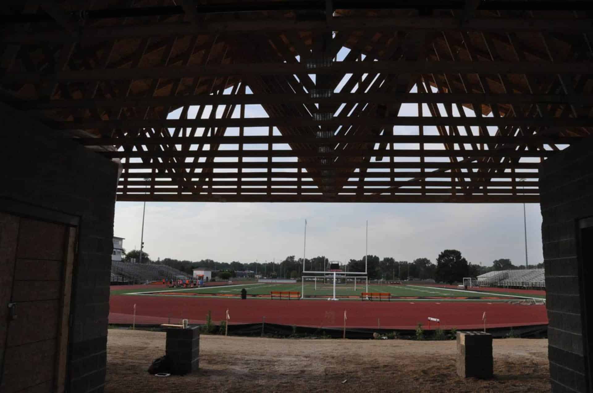 View of a high school football field framed by a covered pavilion.