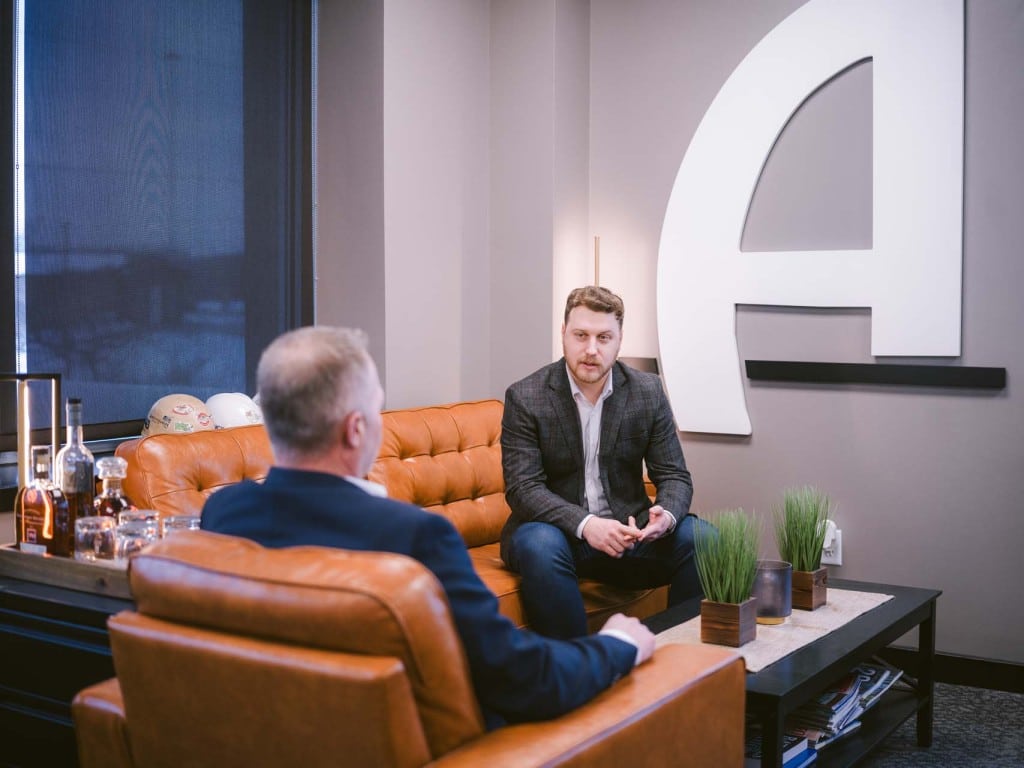 Two colleagues having a discussion in a modern lounge seating area.